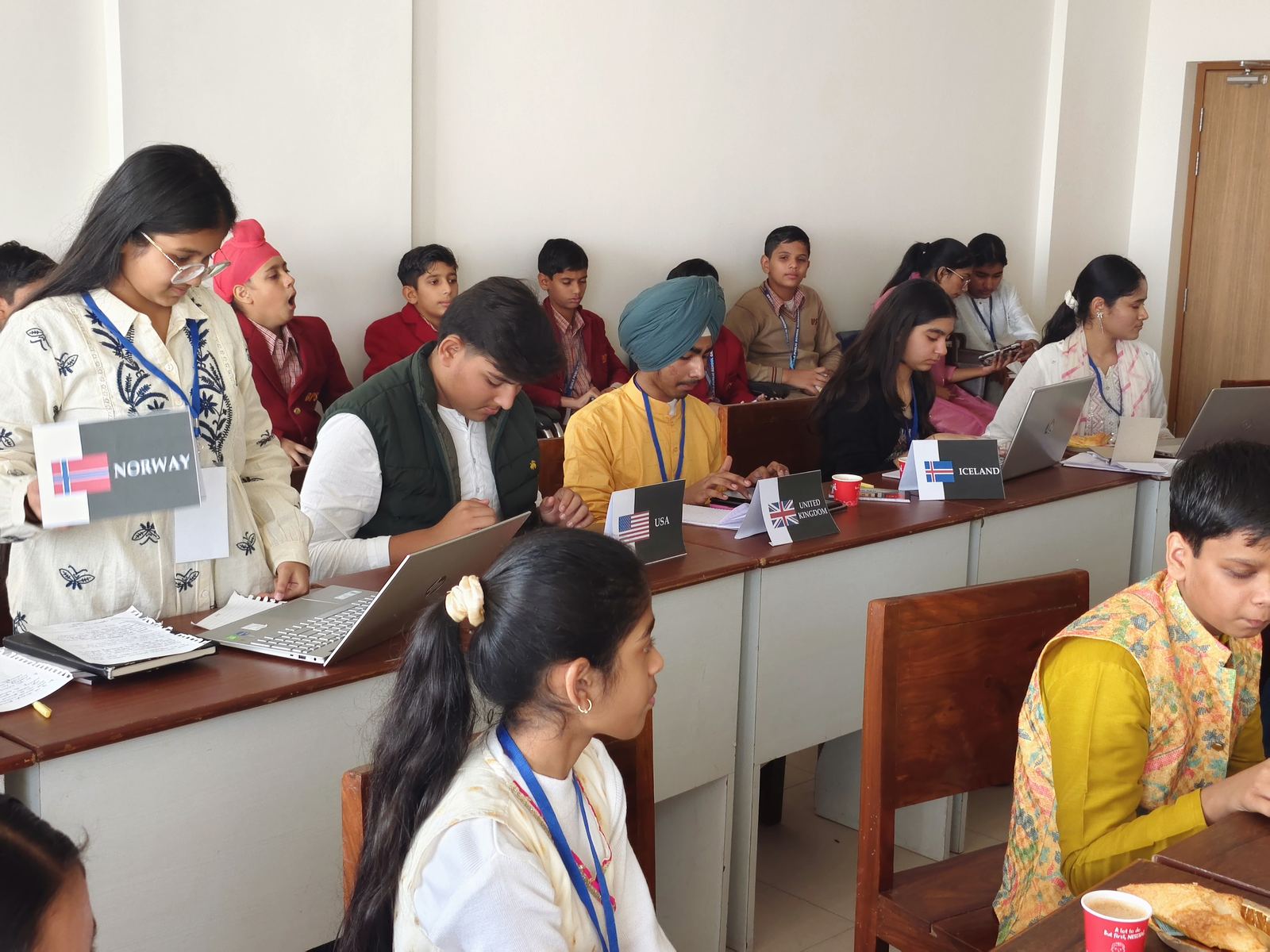 Committee session in progress with delegate placards for Norway, USA, UK and Iceland